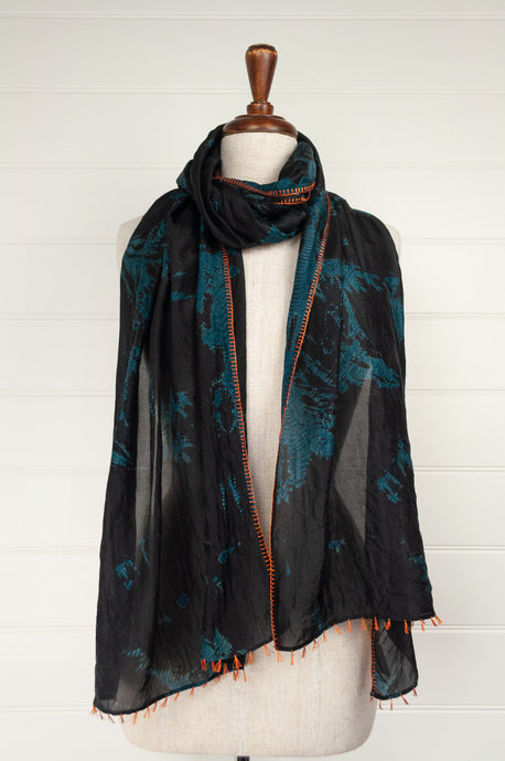 Neeru Kumar fine silk shibori dyed scarf, black with teal green patterning, edge stitched and tassels in neon orange.