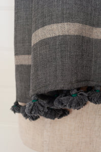 Juniper Hearth woven merino wool scarf, lightweight and very soft, melange dye from charcoal to jade green, with handmade pompoms.