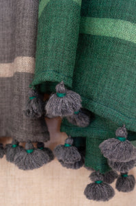 Juniper Hearth woven merino wool scarf, lightweight and very soft, melange dye from charcoal to jade green, with handmade pompoms.