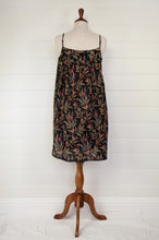 Load image into Gallery viewer, Ethically made pure cotton voile summer nightdress with adjustable straps and pintucked yoke, this nightie is in a wildflower print on black with broderie edging (back view).