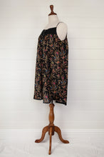 Load image into Gallery viewer, Ethically made pure cotton voile summer nightdress with adjustable straps and pintucked yoke, this nightie is in a wildflower print on black with broderie edging (side view).