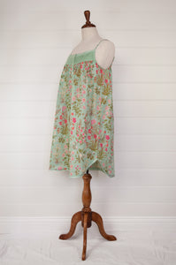 Ethically made pure cotton voile summer nightdress with adjustable straps and pintucked yoke, this nightie is in a mint green floral print with broderie edging (side view).