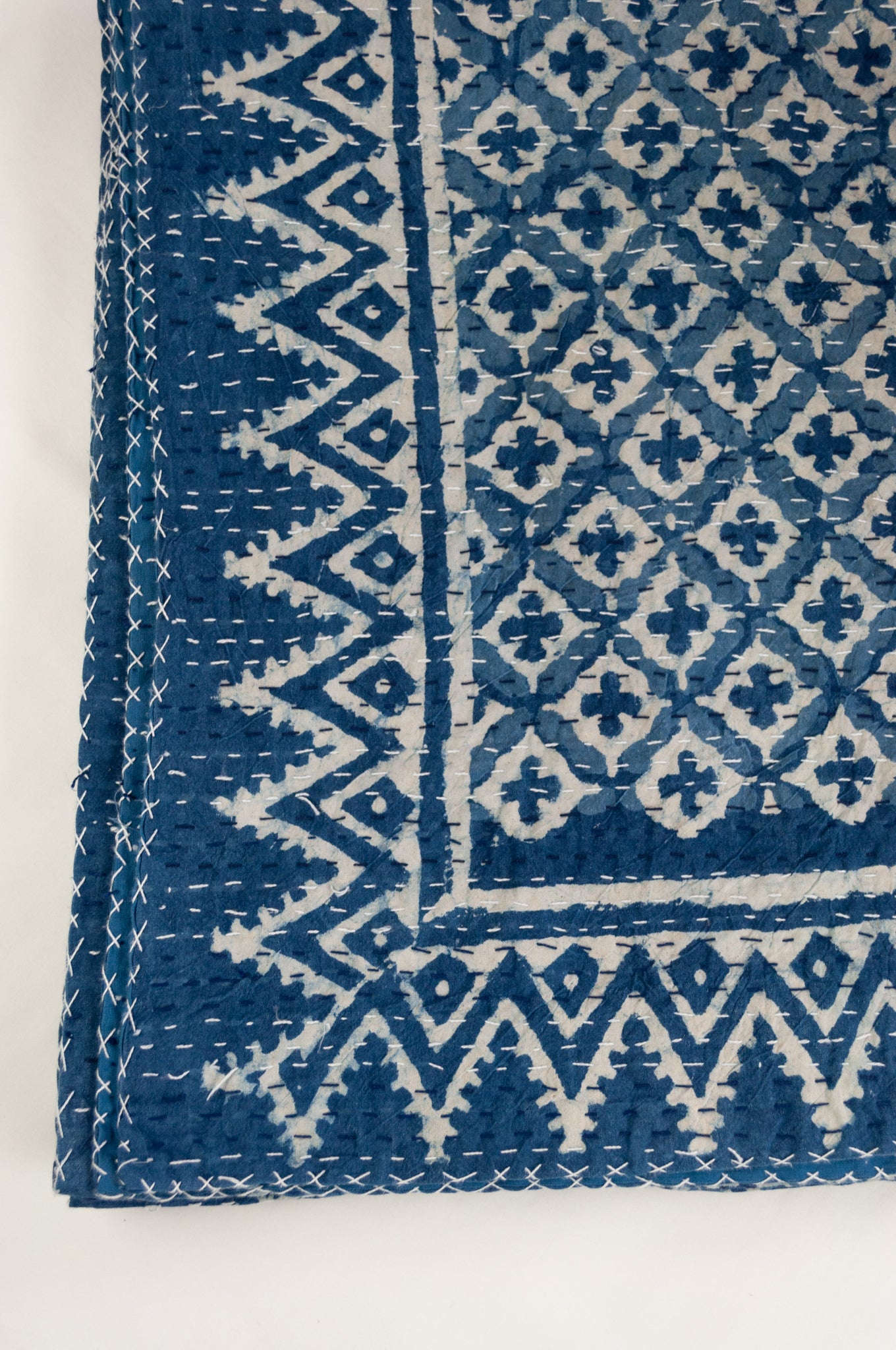Block printed in indigo, blue and white kantha quilt hand made in Jaipur, featuring two tone checks and crosses pattern and decorative border.