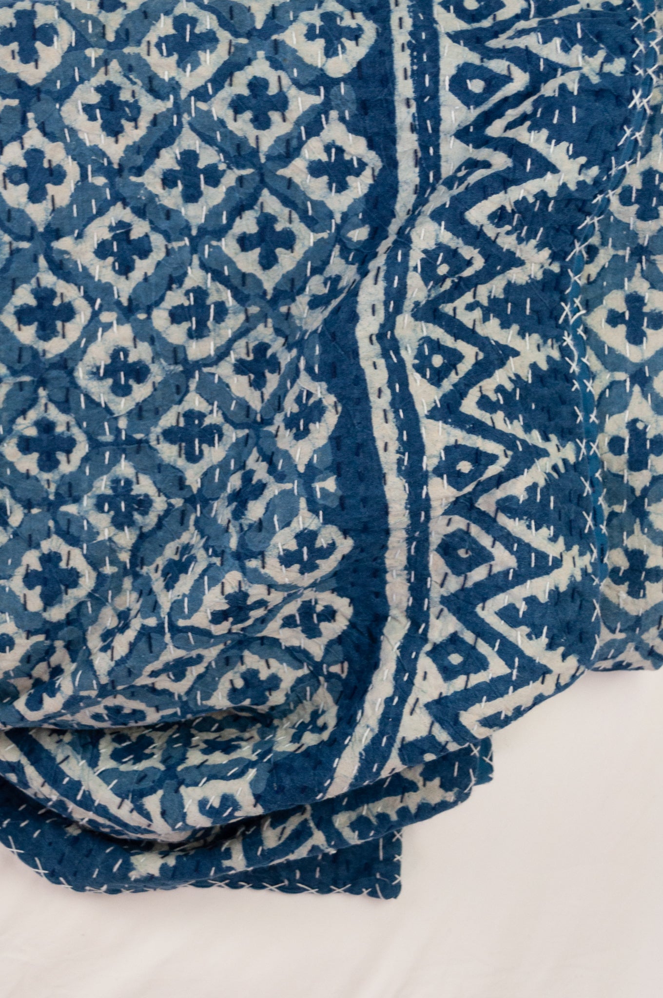 Block printed in indigo, blue and white kantha quilt hand made in Jaipur, featuring two tone checks and crosses pattern and decorative border.