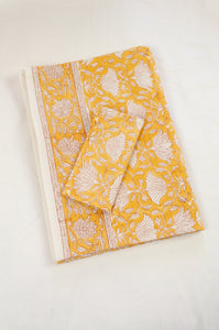 Cotton tablecloth, blockprinted by hand exclusively for Juniper Hearth, Sara floral in white on honey yellow.
