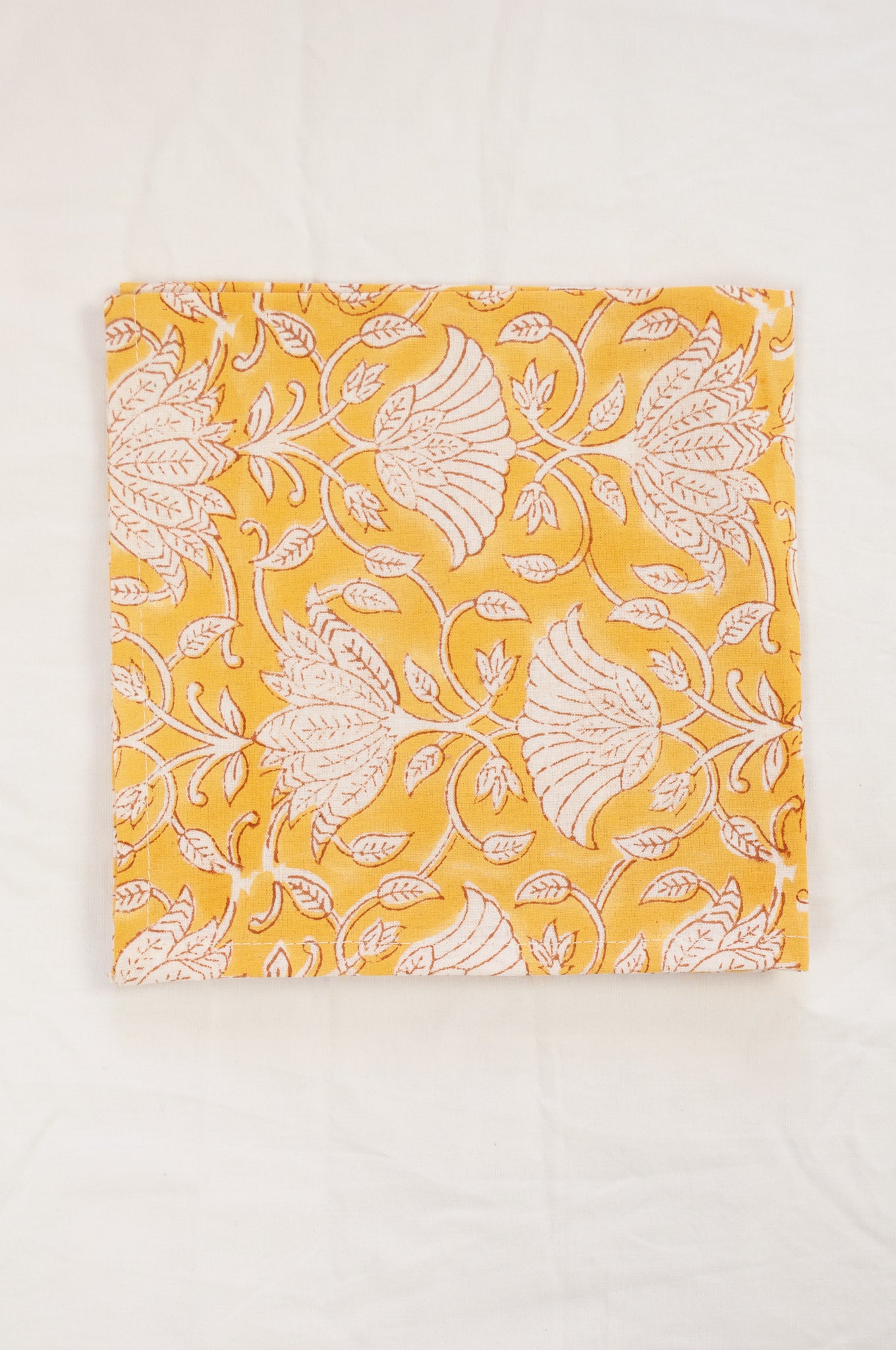 Cotton table napkins, blockprinted by hand exclusively for Juniper Hearth, Sara floral in white on honey yellow.