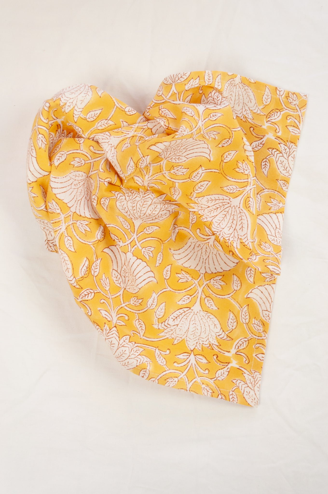 Cotton table napkins, blockprinted by hand exclusively for Juniper Hearth, Sara floral in white on honey yellow.