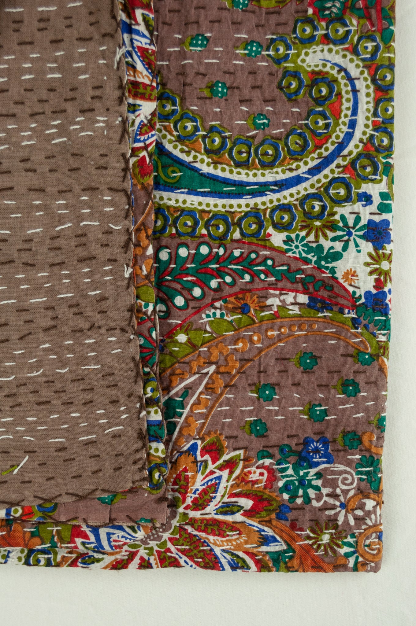Handstitched cotton Kantha quilt paisley on a chocolate brown background, with highlights in olive green, red, blue, tan and white.