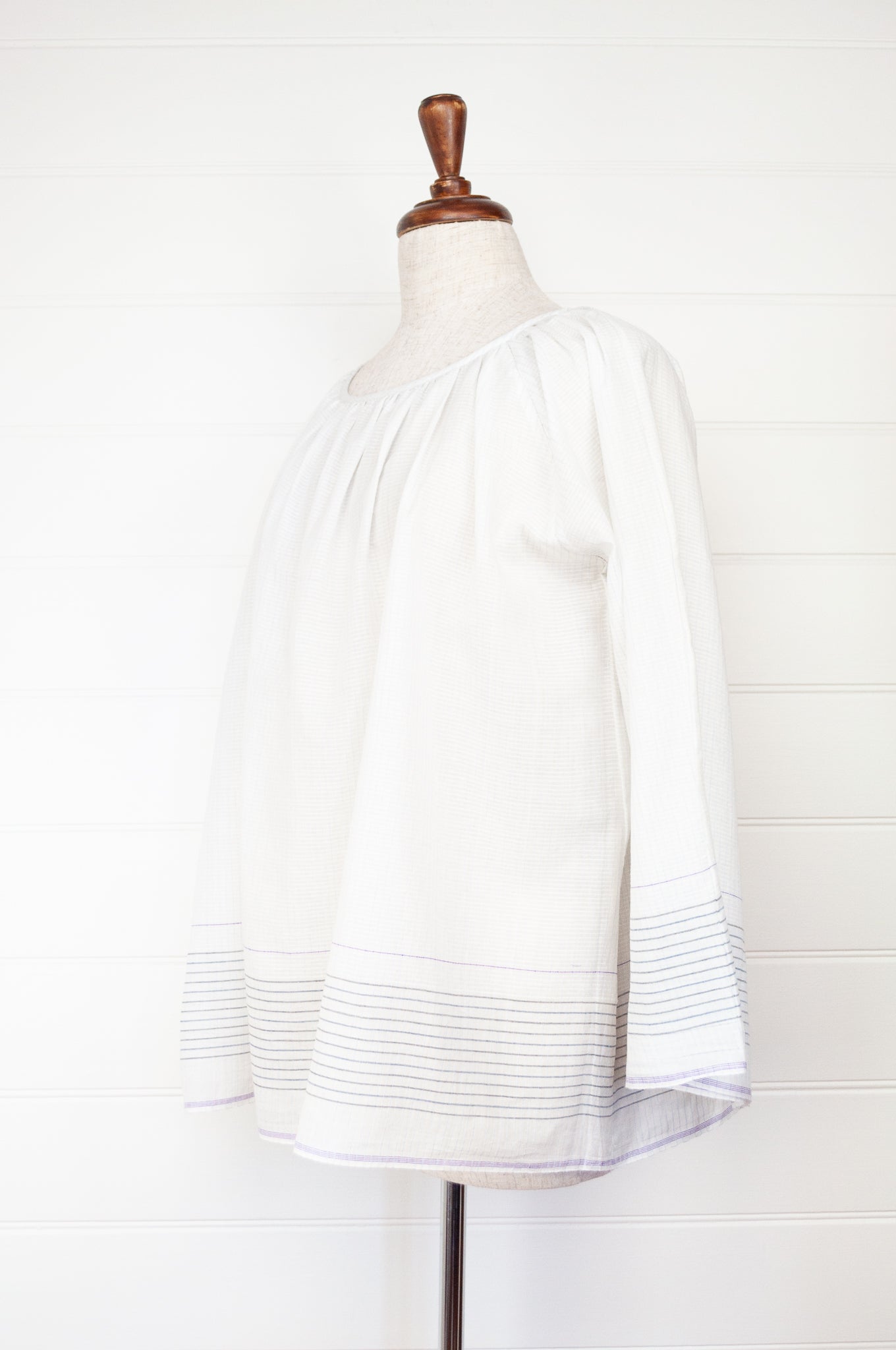 Juniper Hearth Yuka top in fine white cotton with self check, fine black stripe border with lavender highlight, gathered neck, loose fit one size long sleeve smock tunic top.