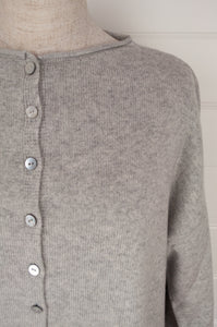 Juniper Hearth ash grey marle reversible one size cashmere cardigan, roll neck edges to neck, sleeves and hem, shell buttons, can be worn as a cardigan or reversed as a sweater.