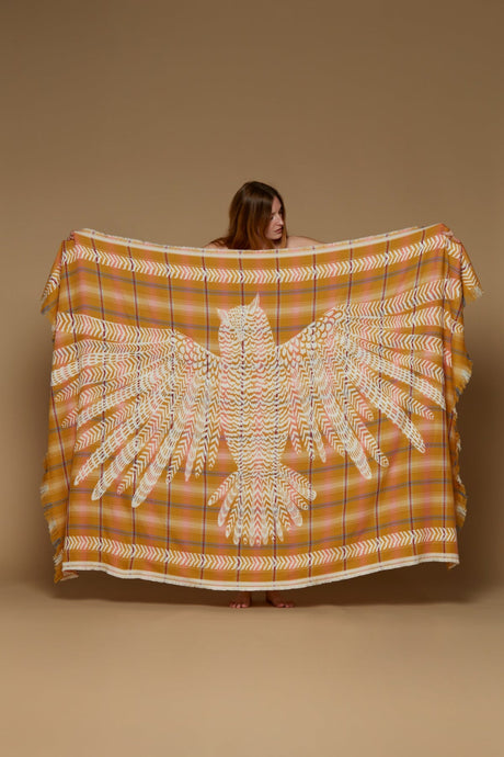 Inoui Editions Hedwige wool throw rug in saffron, white owl silhouette on check background.