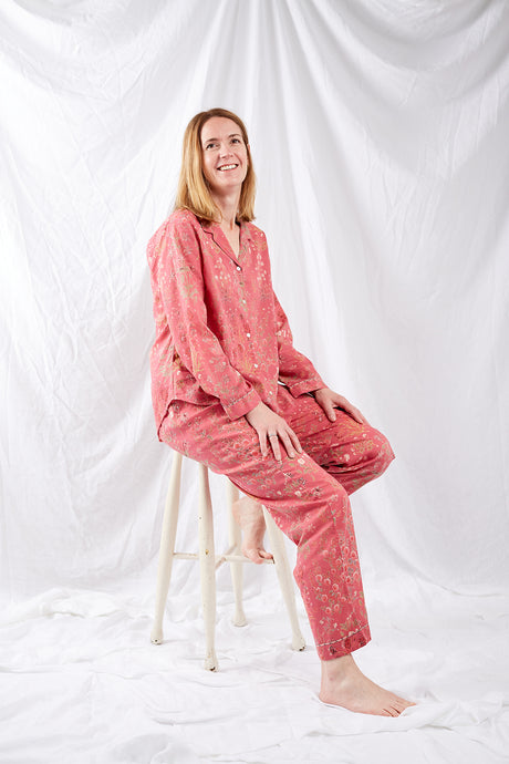 Ethically made cotton voile pyjamas with garden flowers of pink, red and vanilla on a deep raspberry pink red background.
